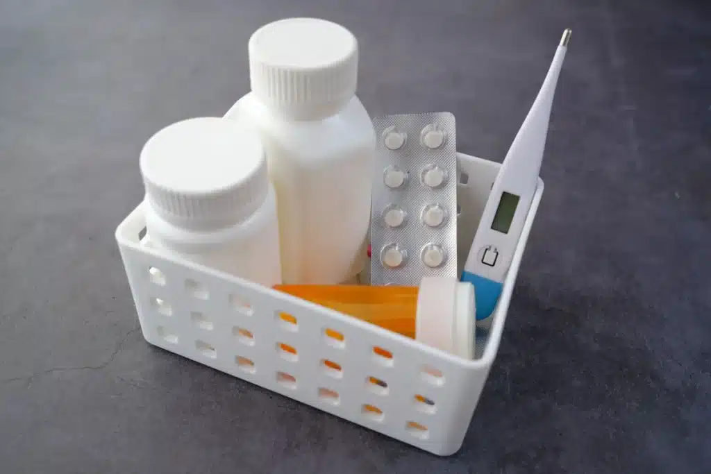 Manos sosteniendo una receta y medicamentos en mostrador de farmacia