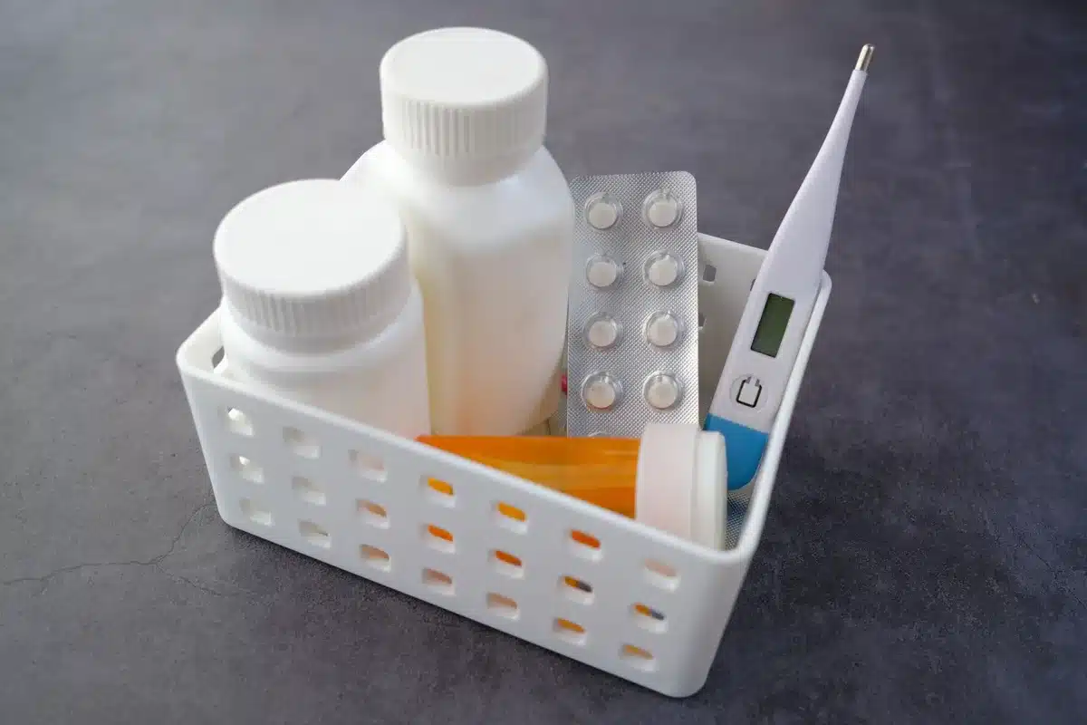 Manos sosteniendo una receta y medicamentos en mostrador de farmacia