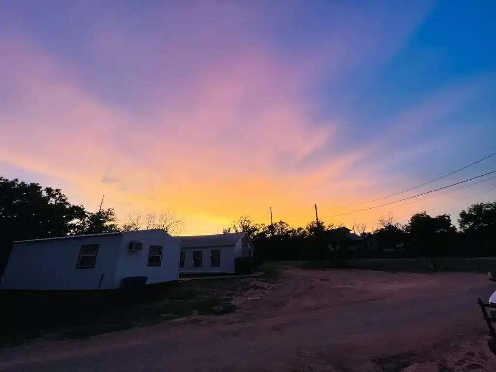 Paisaje desértico de Texas al atardecer con una carretera solitaria y camión antiguo