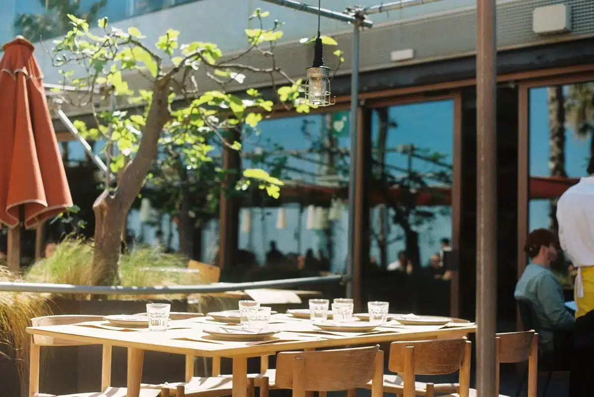 Camarero sirviendo comida en una terraza de restaurante catalán tradicional