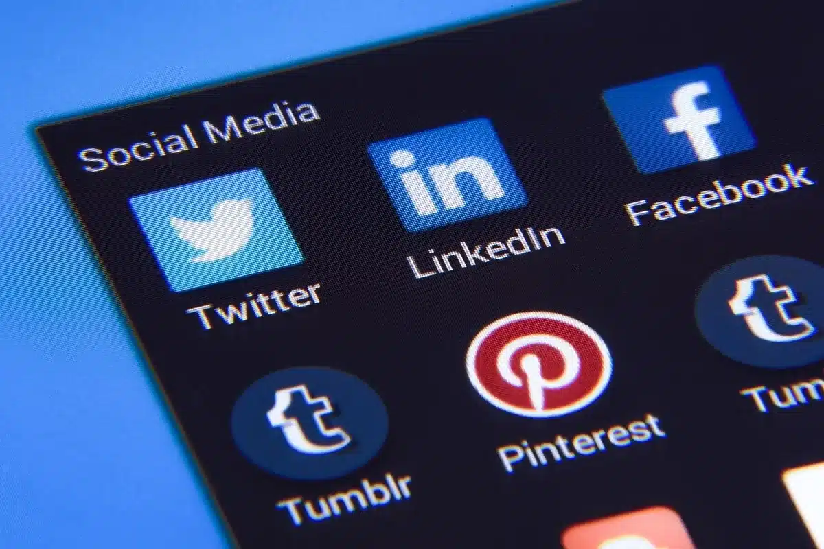 Adolescente con un teléfono inteligente mostrando iconos de redes sociales y notificaciones en la pantalla