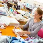 Manos anónimas cosiendo retales en un taller de upcycling textil