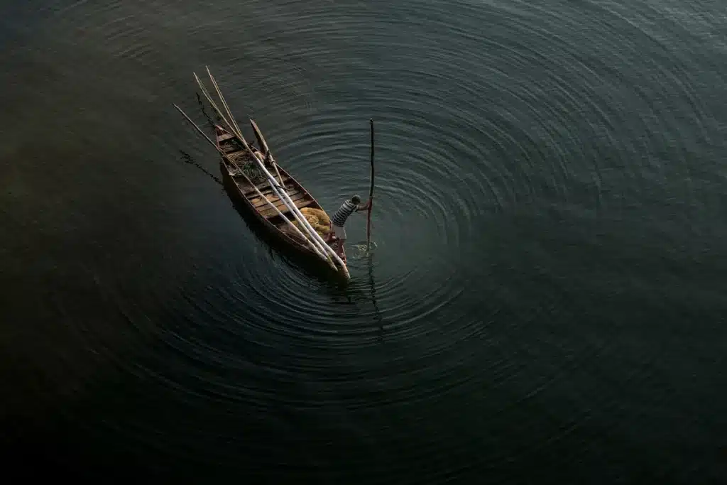 Vista lejana de un pueblo costero islandés con casas y un barco pesquero bajo luz diurna